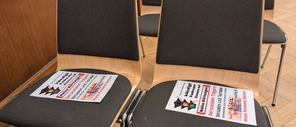 Leere Stühle im BVV-Saal mit Flugblatt zum Pankower Konsens